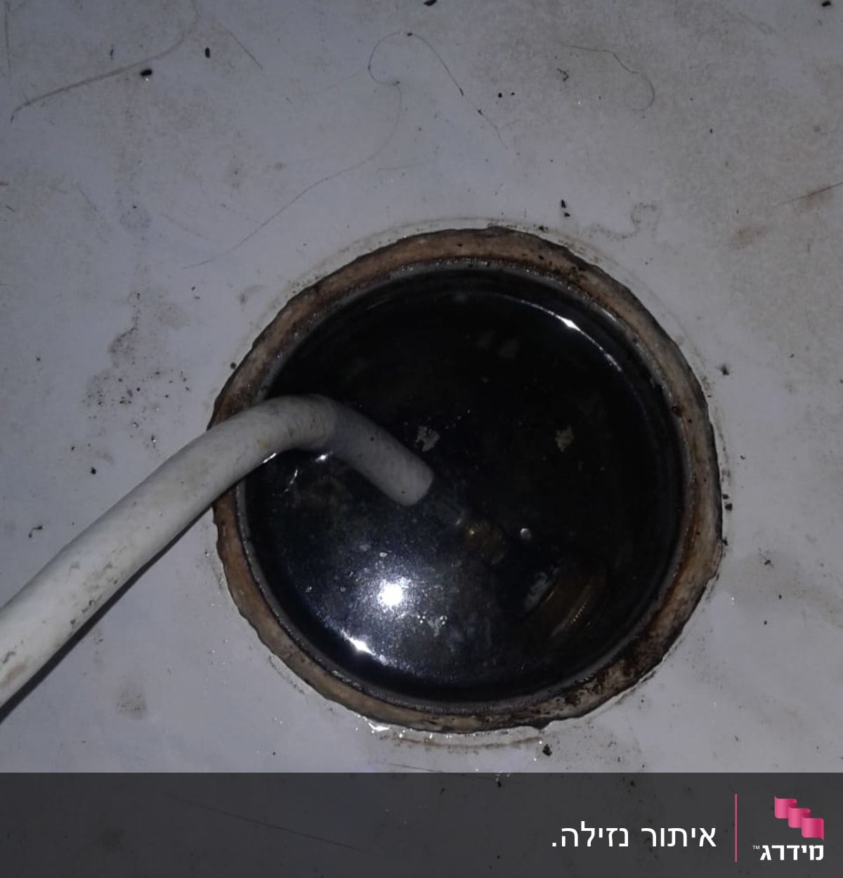 צינור לבן בתוך פתח ניקוז עם מים